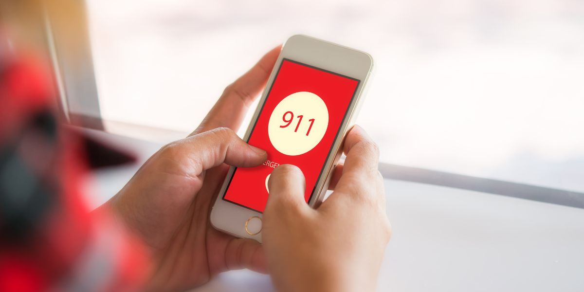 person dialing 911 on cell phone