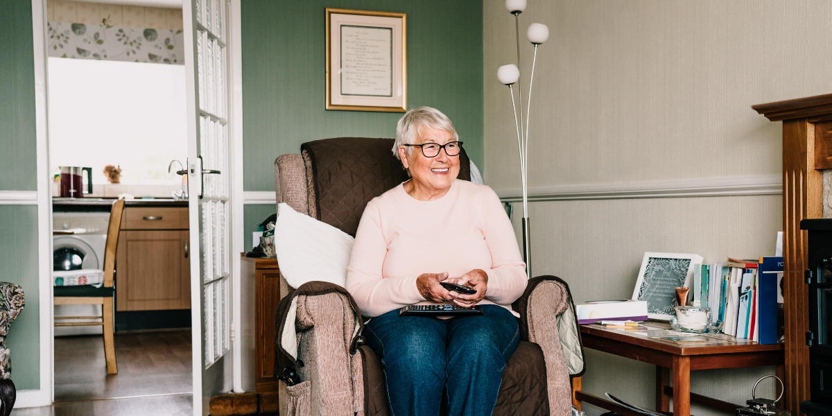 A smiling elder woman in her living room. 